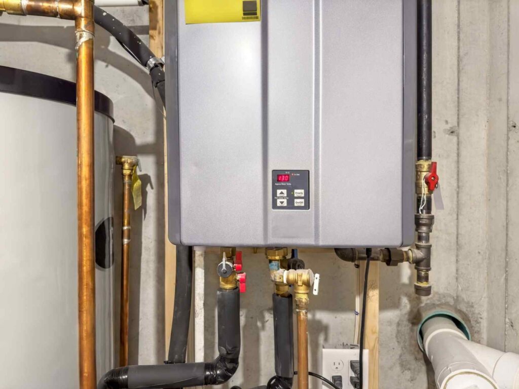 Technician repairing a residential water heater in a Wichita home.